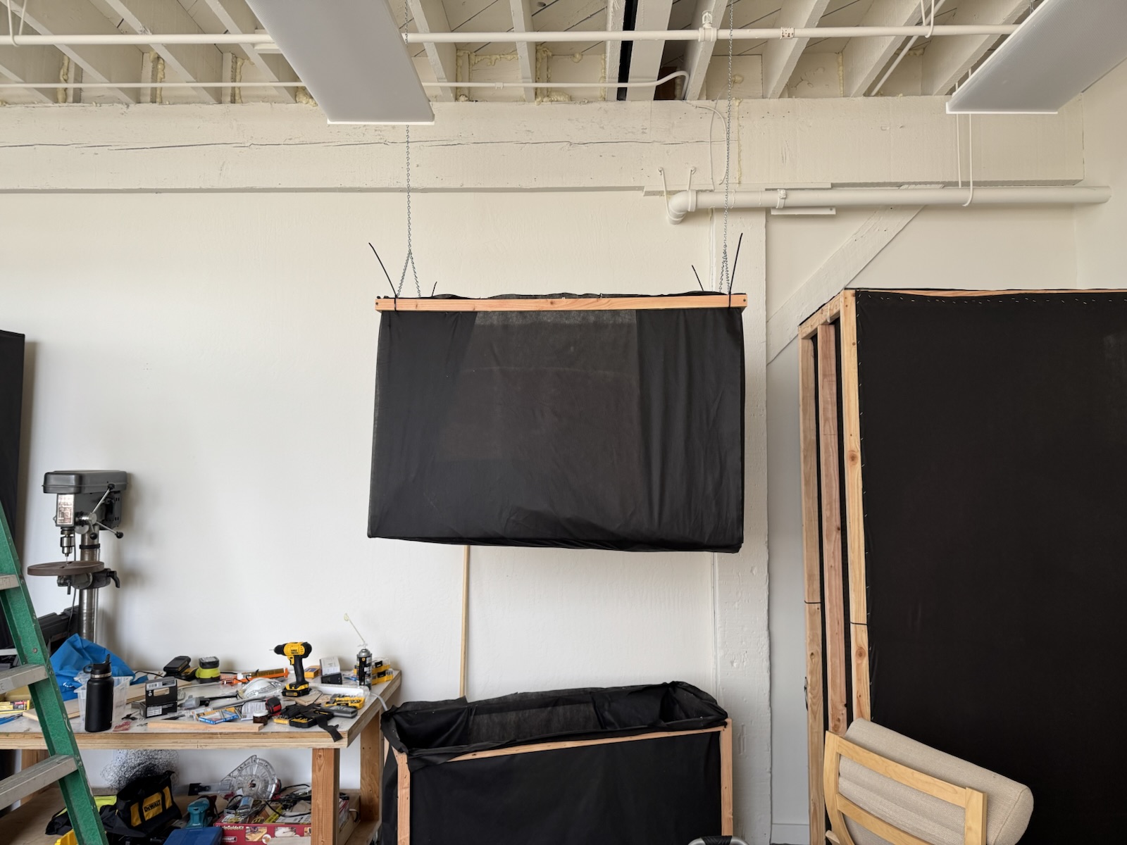 Two finished black absorbers hanging high on the studio wall.