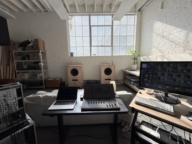 The mix position: a laptop and a Softube Console 1 channel and fader in front of the speakers, with a plugin on the screen at right.