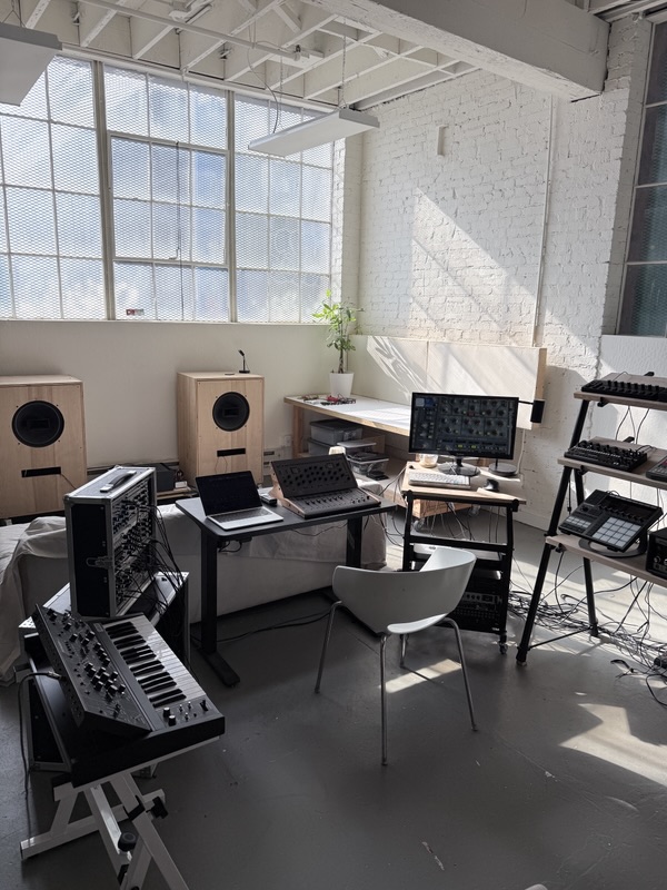 Looking toward the window past a Doepfer modular case and a synth on a stand.